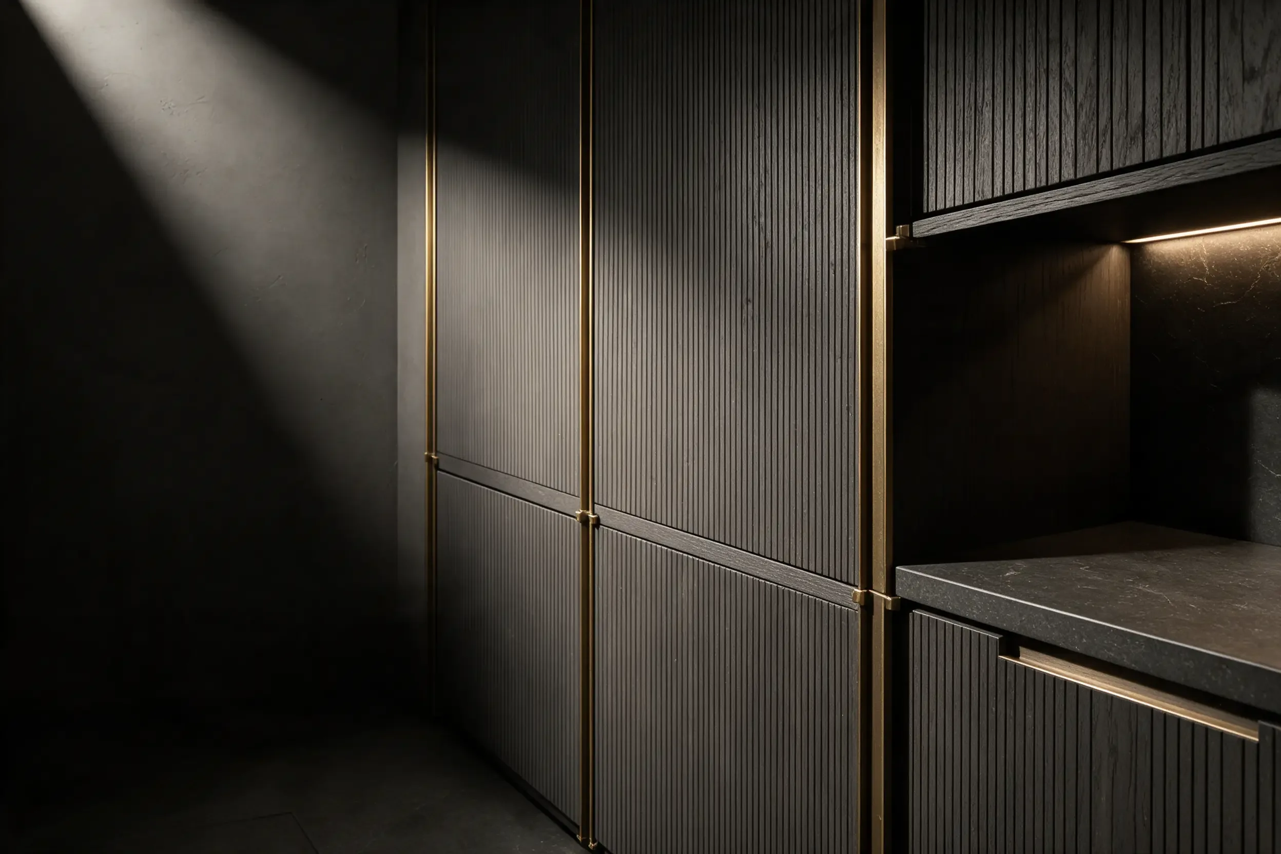 A brass vertical line between two fluted grey panels, lit from inside a niche